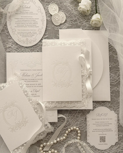 Alyson Lace White wedding invitation with pearl foil-pressed monogram in delicate lace folder, finished with satin ribbon and vintage pearl frame design — Polina Perri. 