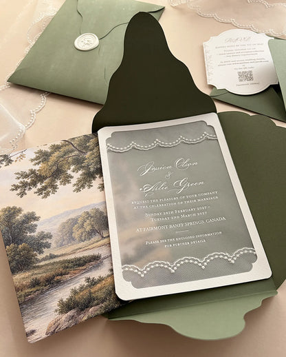 Semi-transparent vellum wedding invitation printed in white ink with lace borders, layered over an antique tapestry landscape print