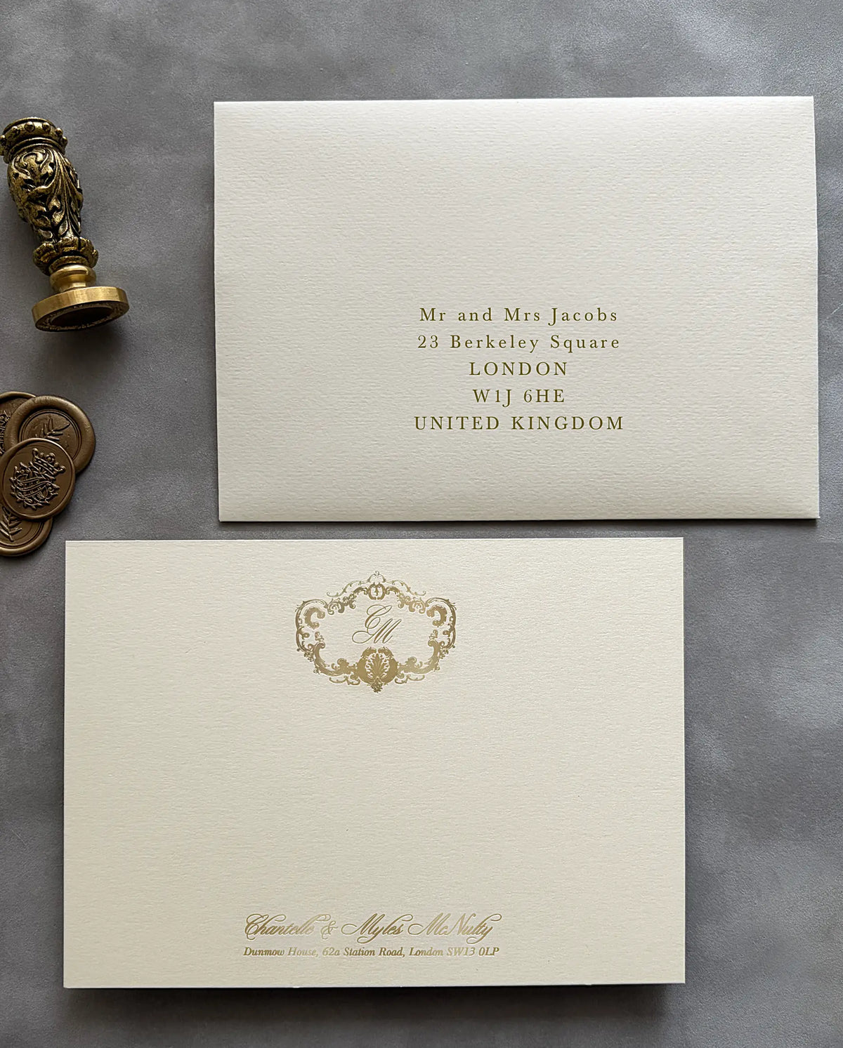 Thank-you card with gold foil crest monogram and a printed guest address on the matching envelope